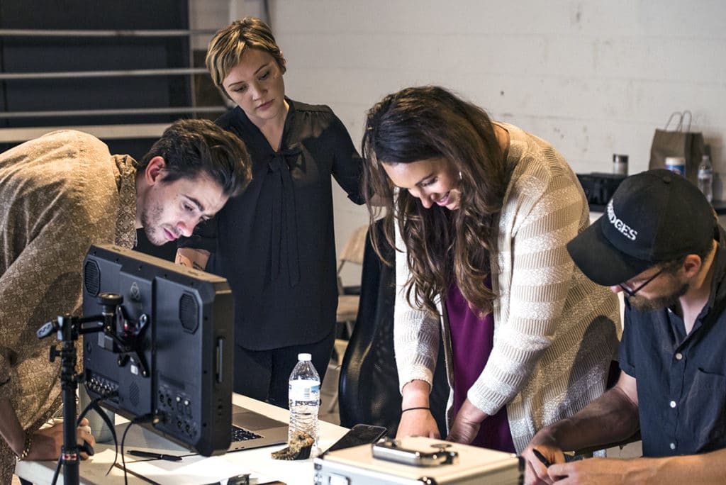 From left to right: Christopher Hawkins, Director of Photography, Georgia Harter, Director & Producer Trista Vonada, the SME for PMC-PBC and Jordan Blaisdell, Assistant Director review the script and check the framing on the monitor.