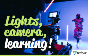 On set production shows videographer and actor on a colorful studio. Words "Lights, camera, learning!" are superimposed